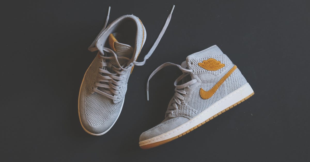 Close-up of fashionable gray and orange high-top sneakers displayed against a minimal background.