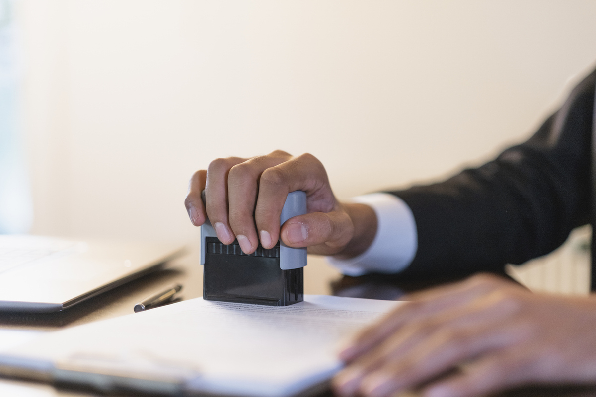 businessman stamping a document at his desk